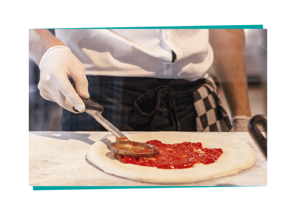 man in gloves making pizza