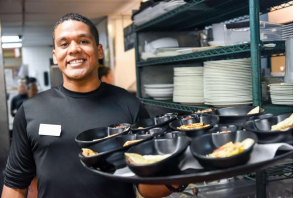 Team member holding tray of food