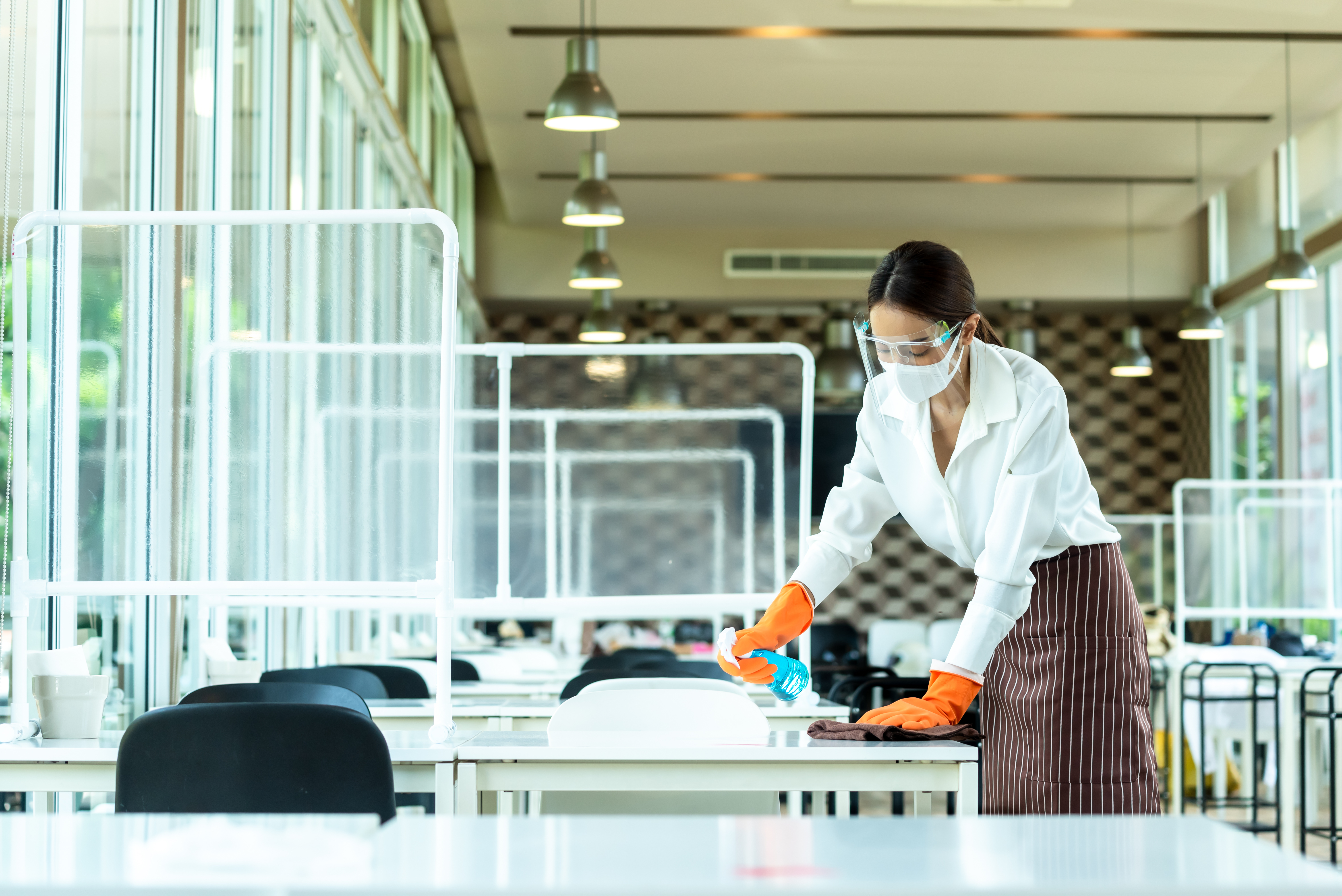 A worker cleaning a table.