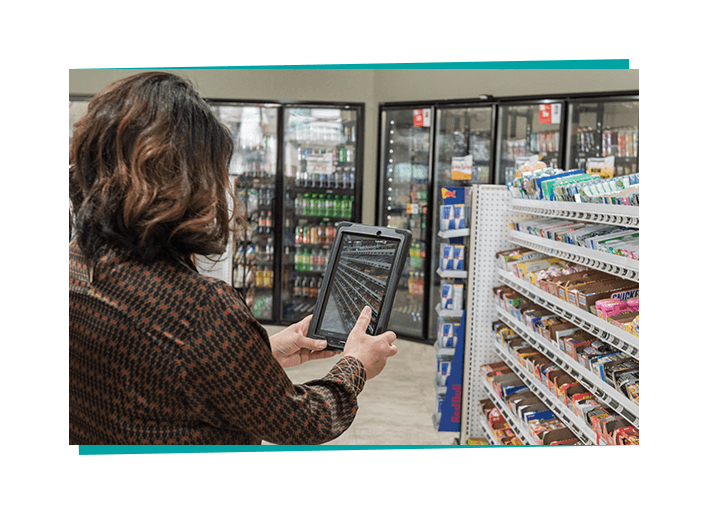 A c-store employee uses an iPad to capture a photo. 