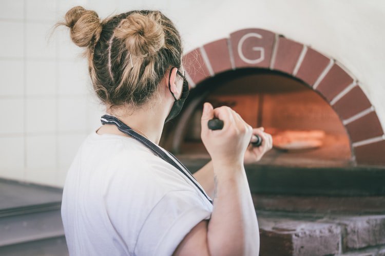 worker cooking pizza