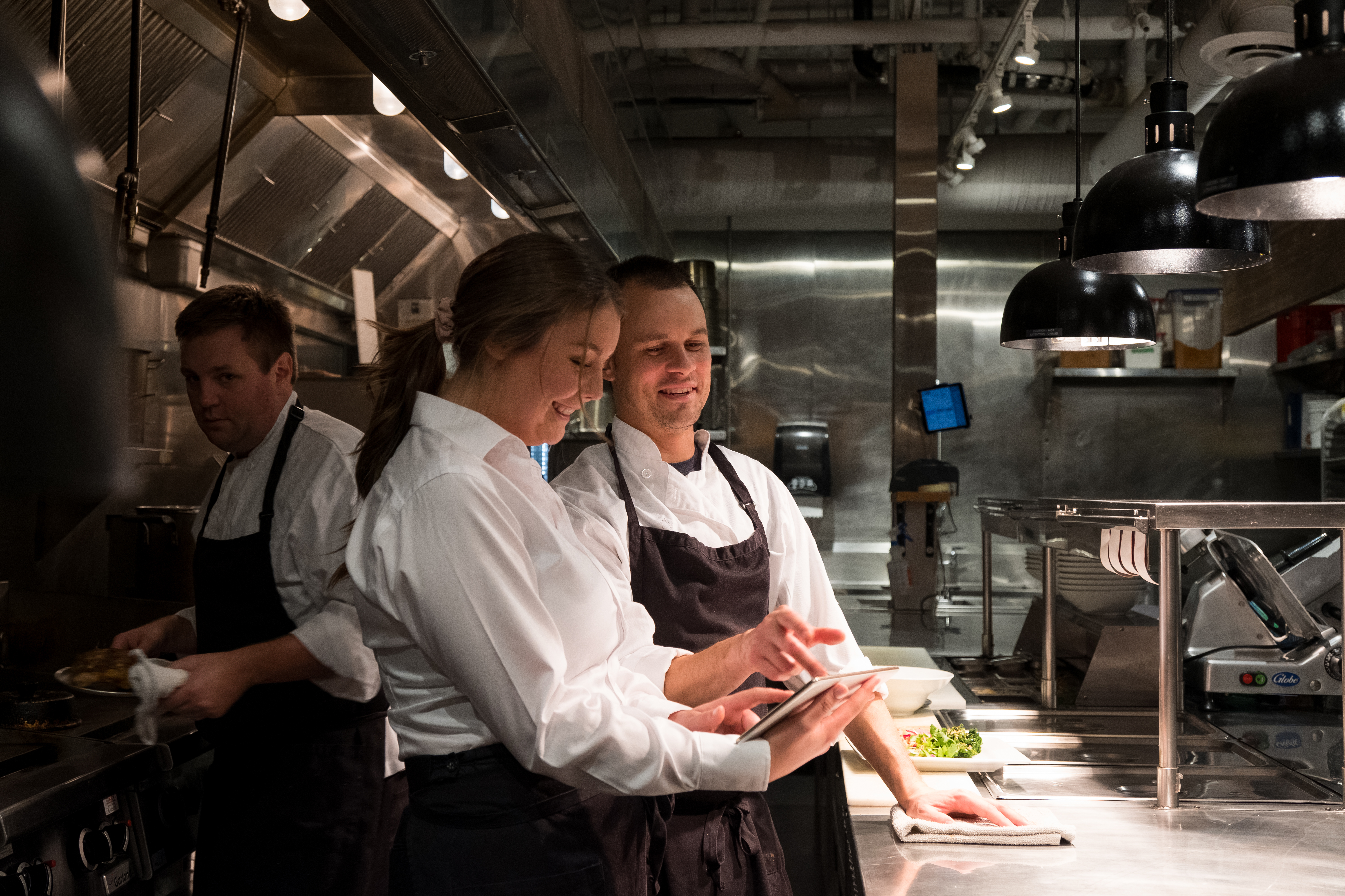 Kitchen staff using an iPad to help complete work