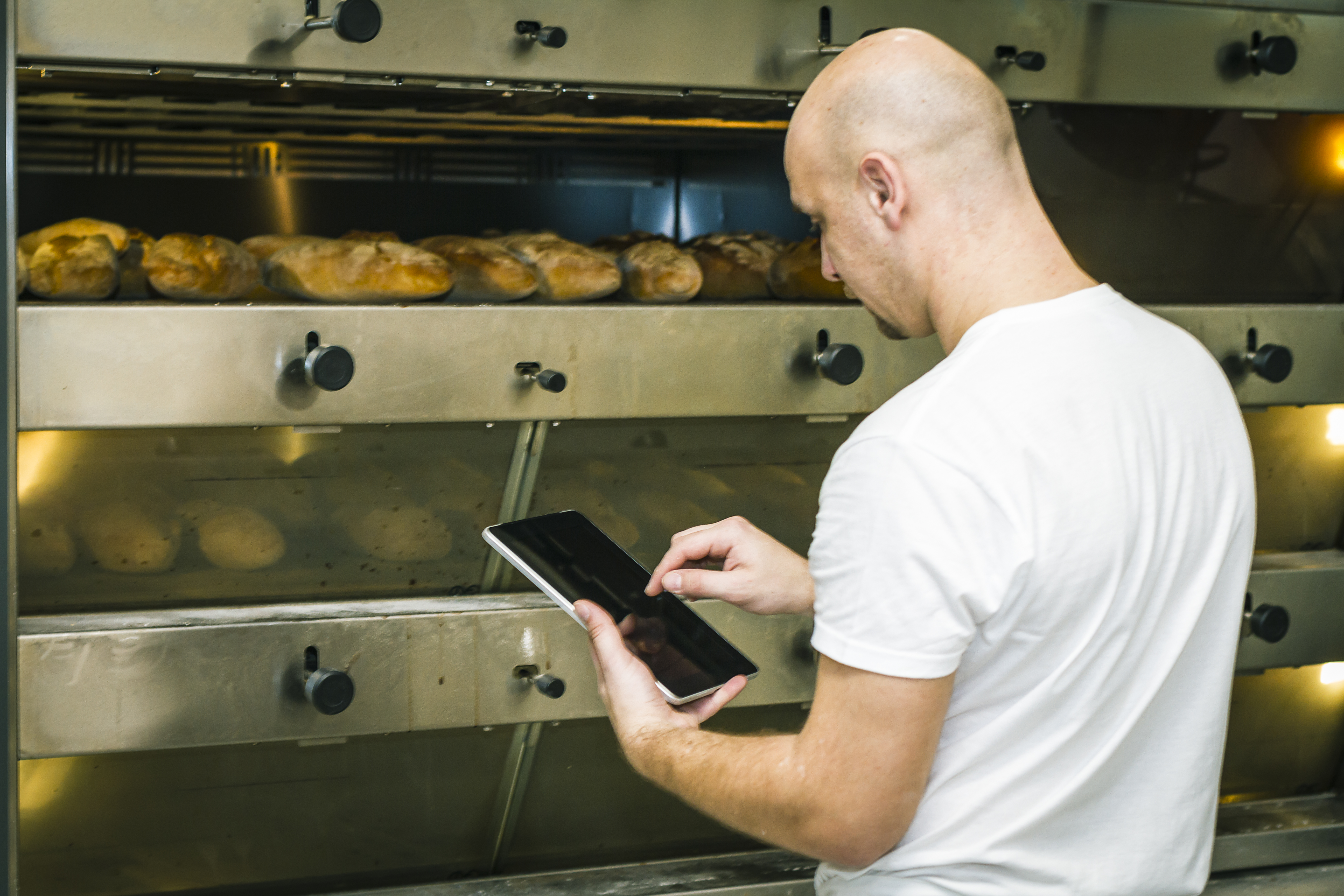 A worker using a tablet to check on food