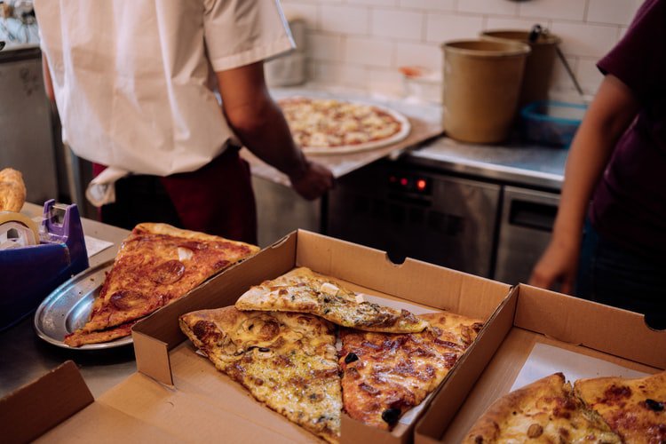 pizza being served and put into boxes